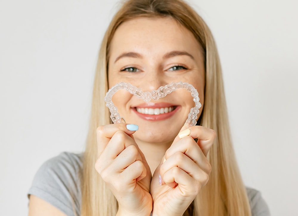 Woman with perfect smile after invisible invisalign aligners treatment