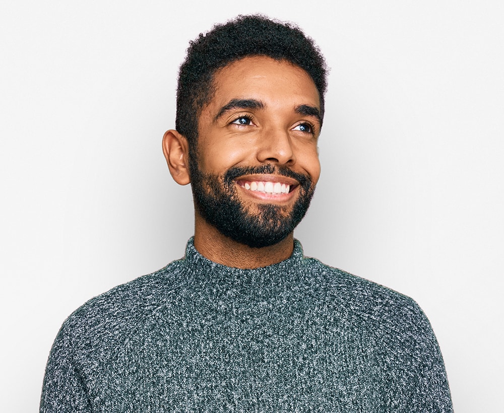 Young african american man wearing casual clothes looking away to side with smile on face, natural expression. laughing confident.